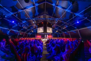 Publiek kijkt vol interesse naar spreker op podium NVVB Jaarcongres