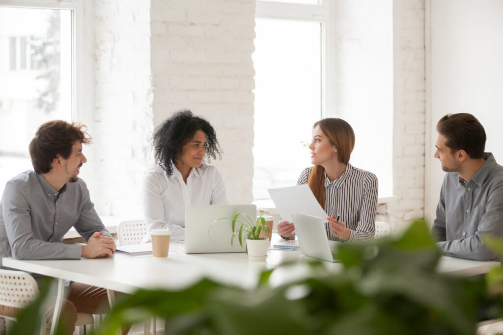 Multiracial male and female colleagues having discussion at team een groep professionals in een vergaderruimte