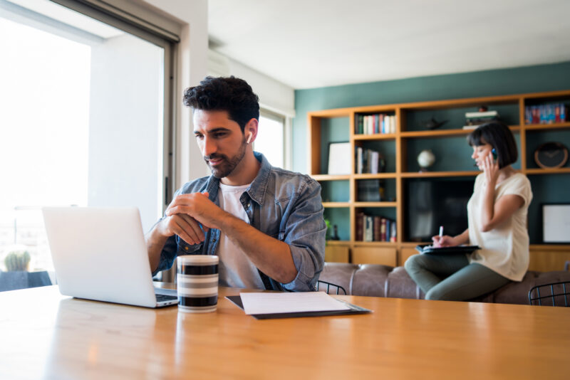Business man working with laptop from home. Mannelijke professional die vanuit huis werk achter een laptop